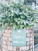 a sign with a plant on a brick wall at Ho Feng Private Hotel 電梯自助民宿 in Ji&#39;an