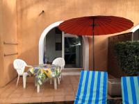 a patio with a table and chairs and an umbrella at 50m Plage T2 Grande Terrasse Vue Mer Climatisé Piscine Chauffée, Parking clos gratuit in Sanary-sur-Mer