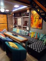 Una habitación con un sofá, una mesa y sillas. en NapPARK Hostel, en Belgrado