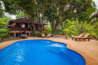 a swimming pool in front of a house at Koh Jum Beach Villas "A member of Secret Retreats" in Ko Jum