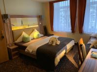 Una habitación de hotel con una cama con un animal de peluche encima. en Hotel Seemeile, en Cuxhaven