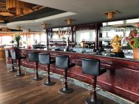 un bar con una fila de taburetes en Leipziger Hotel, en Leipzig