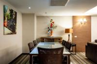 a dining room with a table with chairs and a vase of flowers at Yoyo Hotel in Chiayi City