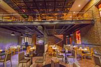 ein Restaurant mit Tischen und Stühlen und einer Backsteinmauer in der Unterkunft The Green Park Ankara in Ankara