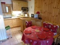 a kitchen with a table with a red table cloth at Le Lièvre Blanc, appartement N°2 in Les Contamines-Montjoie