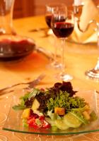 un piatto di insalata su un tavolo con bicchieri da vino di Landhotel Bayerwald a Grafling