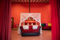 a bedroom with a bed with a canopy and red curtains at Dickman Resort "The Boutique Hotel" in Negombo