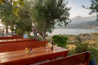 a wooden table with a bottle of wine and glasses at Plakias Bay Hotel in Plakias