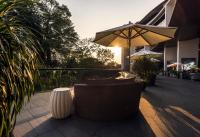 a patio with a table and an umbrella and chairs at Capella Singapore in Singapore