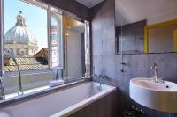a bathroom with a tub and a sink and a window at Palazzetto Rosso - Art Hotel in Siena