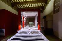 a bedroom with a large bed with red walls at Palazzetto Rosso - Art Hotel in Siena