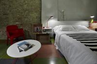 a bedroom with a bed and a table and a chair at Palazzetto Rosso - Art Hotel in Siena