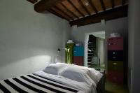 a bedroom with a bed and some dressers at Palazzetto Rosso - Art Hotel in Siena