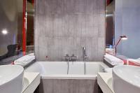 a bathroom with two sinks and a bath tub at Palazzetto Rosso - Art Hotel in Siena