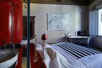 a bedroom with a bed and a desk and a table at Palazzetto Rosso - Art Hotel in Siena