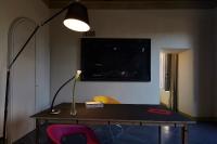 a room with a table with a lamp and a flower on it at Palazzetto Rosso - Art Hotel in Siena