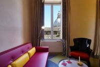 a room with a couch and a chair and a window at Palazzetto Rosso - Art Hotel in Siena