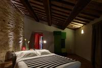 a bedroom with a bed and a brick wall at Palazzetto Rosso - Art Hotel in Siena