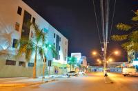 una calle de la ciudad por la noche con palmeras y edificios en Pousada Central, en Feira de Santana