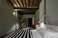 a bedroom with a bed and a red chair at Palazzetto Rosso - Art Hotel in Siena