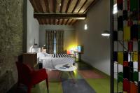 a bedroom with a bed and a table and a chair at Palazzetto Rosso - Art Hotel in Siena