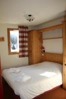 a bedroom with a large white bed with a window at Les Alpages De Val Cenis by Resid&amp;co in Lanslebourg-Mont-Cenis