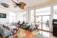 a dining room with people sitting at tables in a restaurant at Majestic Hotel South Beach in Miami Beach