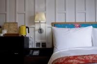 a bedroom with a bed with a white pillow and a lamp at Reddot Hotel in Taichung
