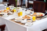 Una mesa con alimentos para el desayuno y vasos de jugo de naranja. en The Moon Residence & Spa, en Siem Reap
