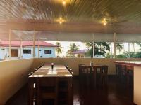 a dining area with tables and chairs in a restaurant at Tongatok Cliff Resort in Mambajao
