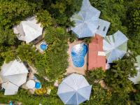 Una vista aérea de una piscina con sombrillas. en Tamarindo Village Hotel, en Tamarindo