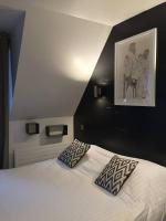 a bedroom with a bed with two pillows on it at Hôtel-Restaurant La Mascotte in La Baule