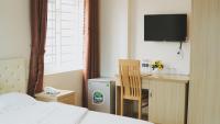 Un dormitorio con una cama, un escritorio y un televisor. en Hoang Ngan 2 Hotel - TP. Vinh, en Vinh