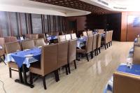 a restaurant with tables and chairs with blue tablecloths at BROAD BEAN KANNUR in Kannur