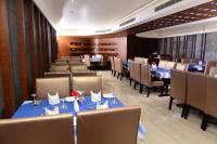 a dining room with blue tables and chairs at BROAD BEAN KANNUR in Kannur