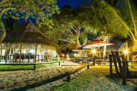 a group of tables and umbrellas on a beach at night at Manico Camp in Portinho da Inhaca