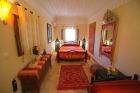 Un dormitorio con una cama y un espejo grande. en Riad Dar Rita, en Ouarzazate