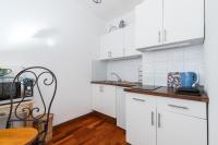 a kitchen with white cabinets and a wooden table at Appartement Nice Port in Nice