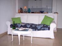 a white couch with green pillows and a table at Appartement Nice Port in Nice