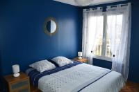 a blue bedroom with a bed and a window at Appartement Le Grand Parc in Châteauroux