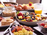 ein Tisch mit Tellern voller Frühstücksspeisen und Getränken in der Unterkunft Hyatt Place Sandestin at Grand Blvd in Destin