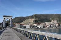 a bridge over a body of water with a city at Camping le Rhône in Tournon-sur-Rhône