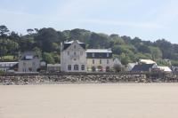 a large house sitting on top of a stone wall at Le Château de Sable in Plougasnou