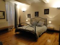 Un dormitorio con una cama negra con almohadas. en Chambres d&#39;hôtes Belle Occitane, en Tarascon-sur-Ariège