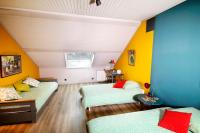 two beds in a room with yellow and blue walls at Maison des Orfèvres in Arbois