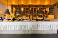 Una barra con luces colgantes negras sobre un mostrador. en Song Hotel Sydney, en Sídney