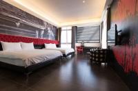 a bedroom with two beds and a red wall at Bookline B&amp;B in Hualien City