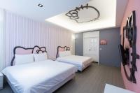 two beds in a room with pink and white at Bookline B&amp;B in Hualien City