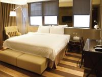 a bedroom with a large bed and a desk and window at Hotel Relax I in Taipei