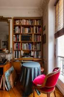 a room with a table and a book shelf with books at Veeve - Artistic in Pigalle in Paris